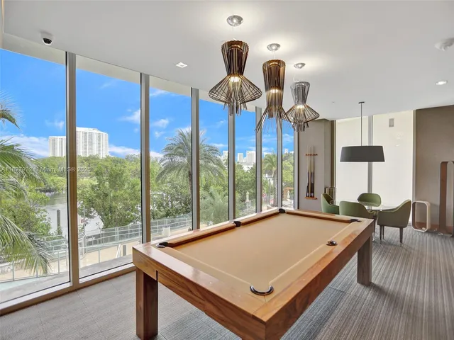 a view of a living room with a floor to ceiling window and wooden floor