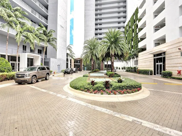 a palm tree sitting in front of a building