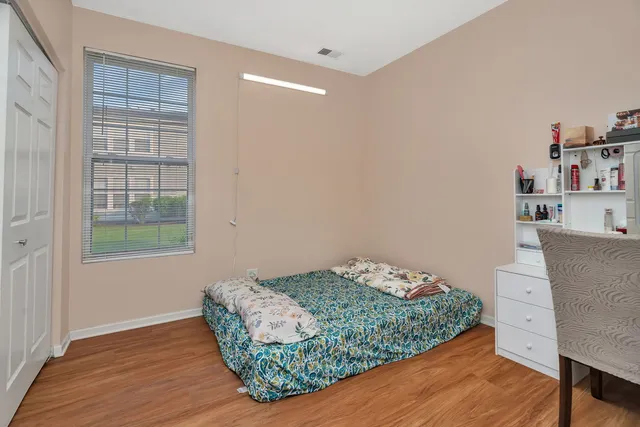 a room with a bed and a wooden floor