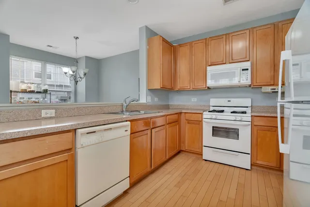 a kitchen with white cabinets sink and appliances