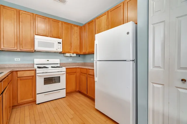 a white refrigerator freezer and a wooden floor
