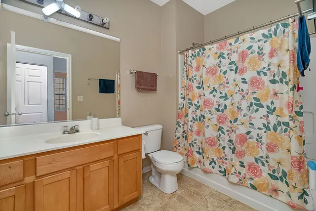 a bathroom with a granite countertop sink a toilet and a mirror