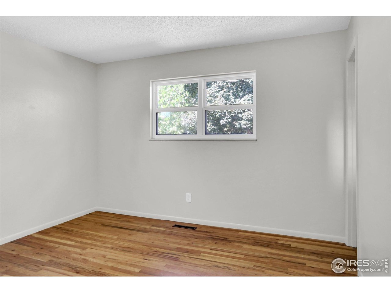 4630 Macky Way Boulder, CO 80305 - Photo 19 of 40 an empty room with wooden floor and window