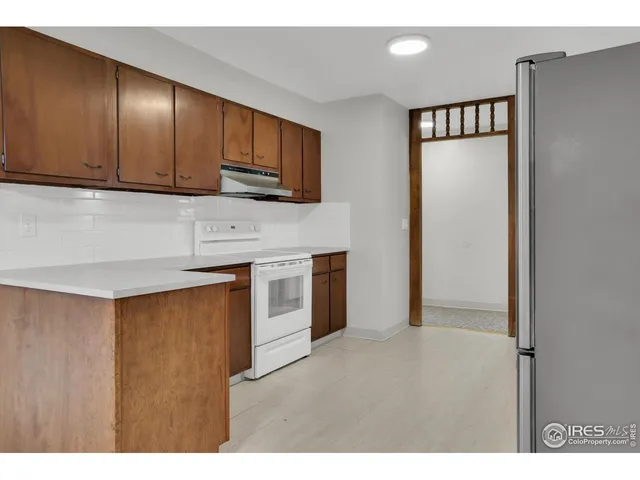 a kitchen with stainless steel appliances granite countertop a refrigerator a sink dishwasher and wooden cabinets