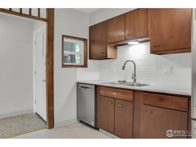 a kitchen with a sink a refrigerator and cabinets