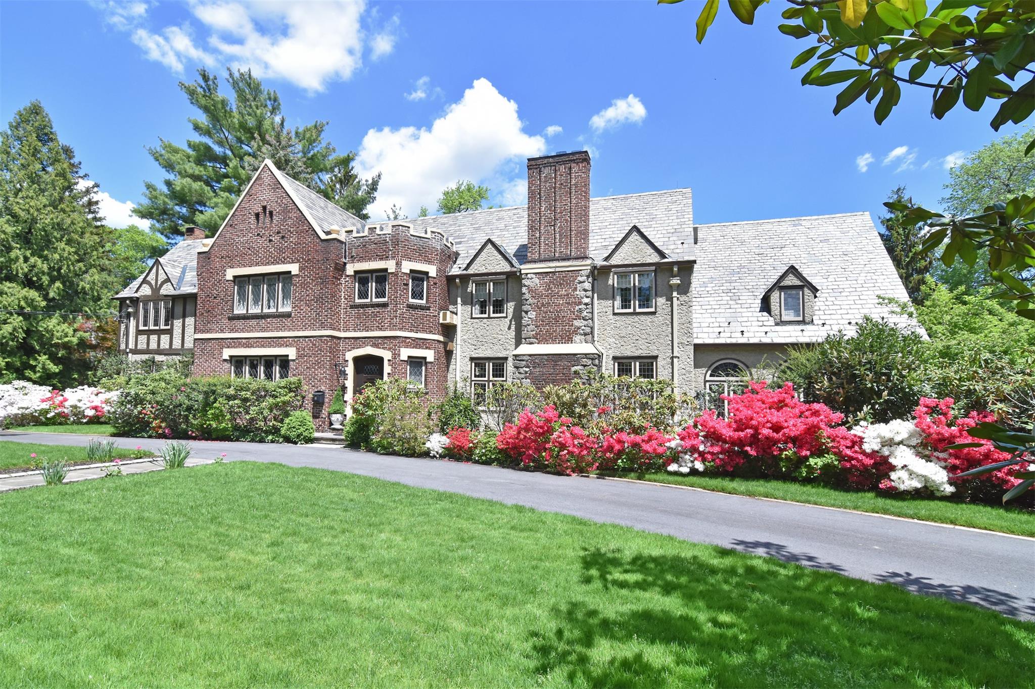 a front view of a house with a big yard and potted plants
