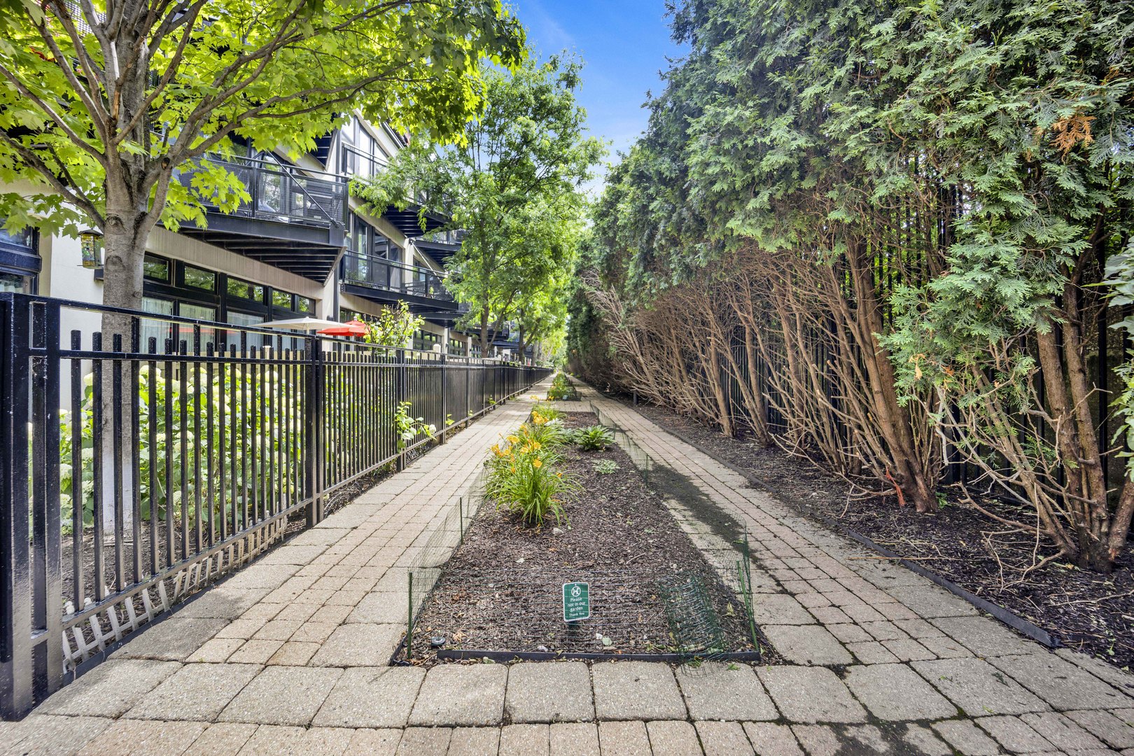 1111 West 15th Street, Unit 224 Chicago, IL 60608 - Photo 27 of 71 a view of a pathway with a wrought fence