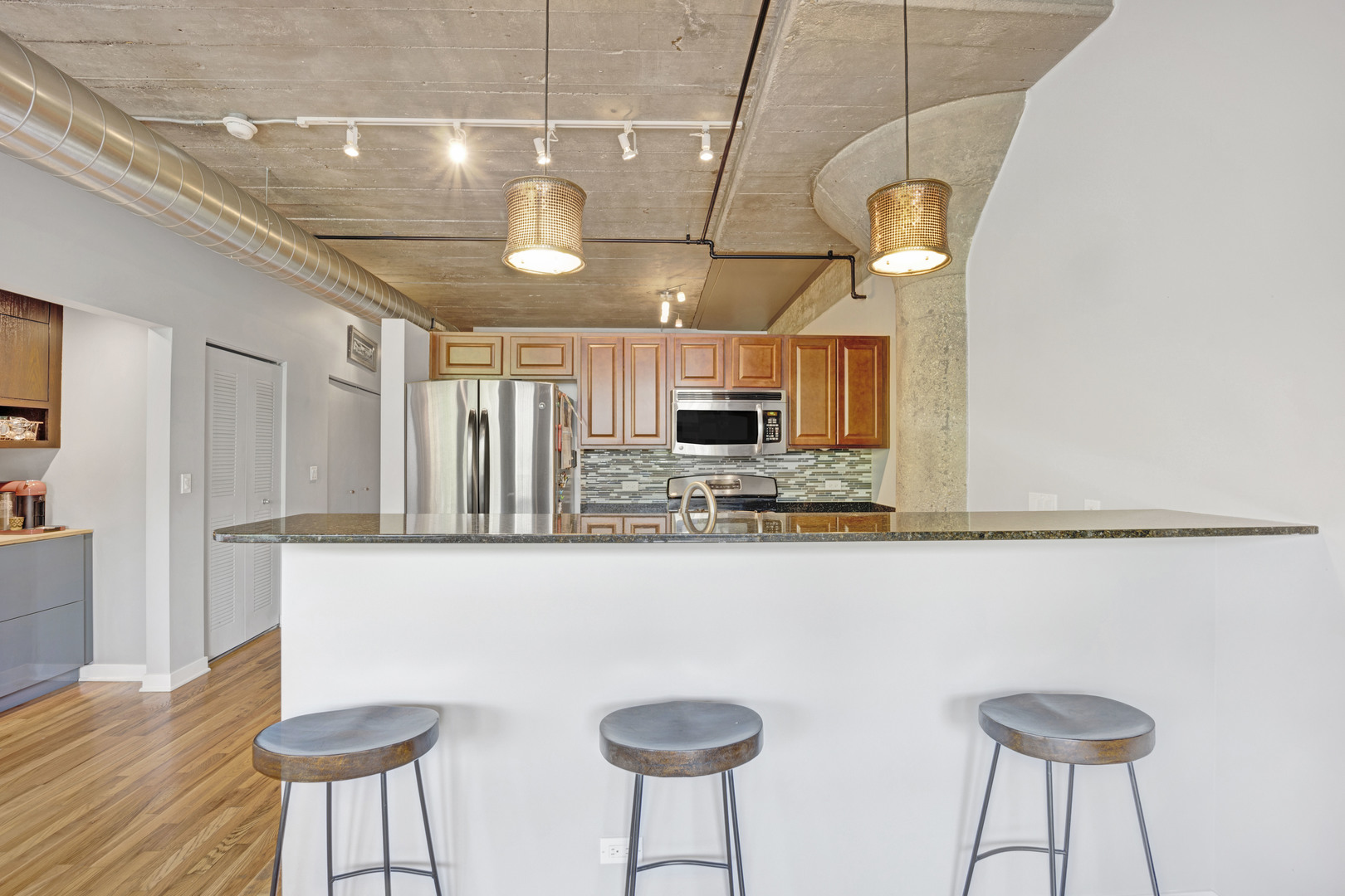 1111 West 15th Street, Unit 224 Chicago, IL 60608 - Photo 6 of 71 a kitchen with stainless steel appliances granite countertop a sink a stove cabinets and chairs