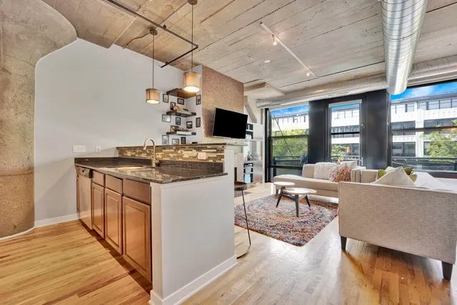 a hallway with stainless steel appliances a sink and wooden floor