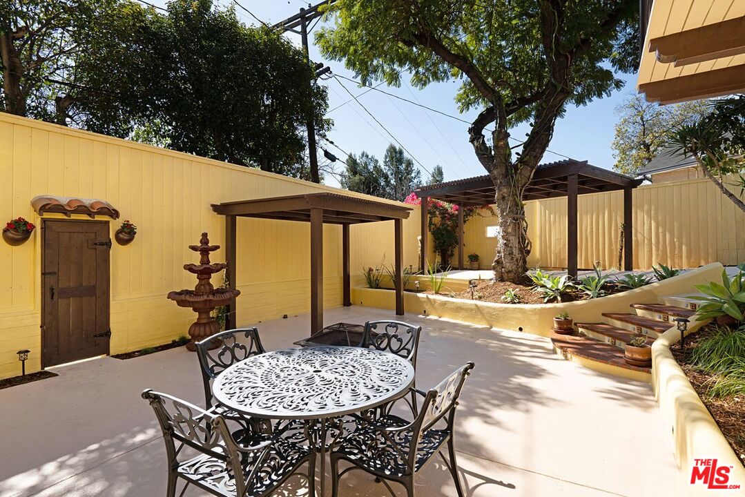 3932 Roderick Road Los Angeles, CA 90065 - Photo 34 of 43 a view of a patio with table and chairs potted plants and large tree