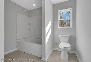 a white toilet sitting next to a bath tub