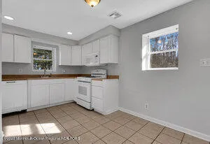 a kitchen with granite countertop white cabinets and white appliances
