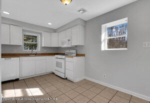 1429 Lakewood Road Manasquan, NJ 08736 - Photo 14 of 26 a kitchen with granite countertop white cabinets and white appliances
