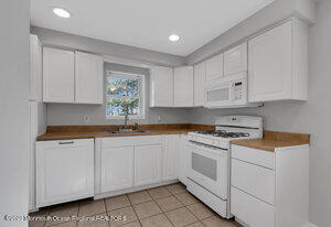 1429 Lakewood Road Manasquan, NJ 08736 - Photo 18 of 26 a kitchen with granite countertop white cabinets white stainless steel appliances and sink