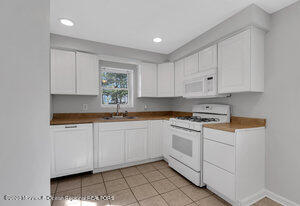 1429 Lakewood Road Manasquan, NJ 08736 - Photo 19 of 26 a kitchen with granite countertop white cabinets and white appliances