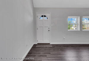 1429 Lakewood Road Manasquan, NJ 08736 - Photo 5 of 26 a view of an empty room with wooden floor and a window