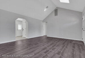 1429 Lakewood Road Manasquan, NJ 08736 - Photo 7 of 26 a view of an empty room with wooden floor and a window