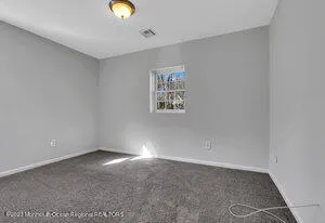 a view of an empty room with window and closet