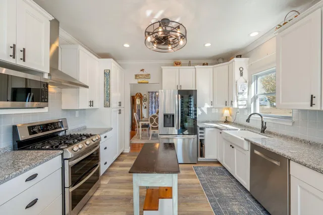 a kitchen with stainless steel appliances granite countertop a sink and a refrigerator