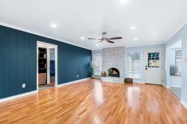 a view of empty room with wooden floor and fireplace