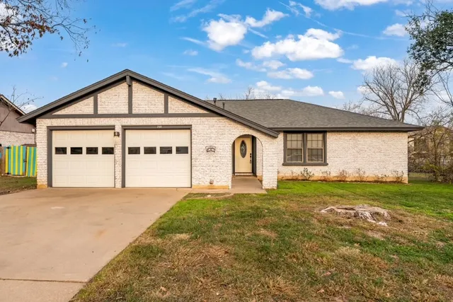 a view of a house with a big yard and large tree