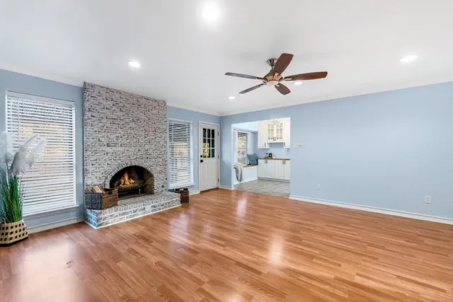 a view of a livingroom with a fireplace a ceiling fan and a fireplace
