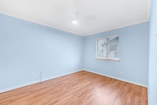 an empty room with windows and fireplace