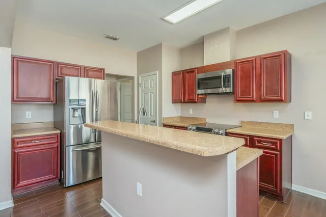 a kitchen with stainless steel appliances granite countertop a refrigerator stove top oven a sink and dishwasher