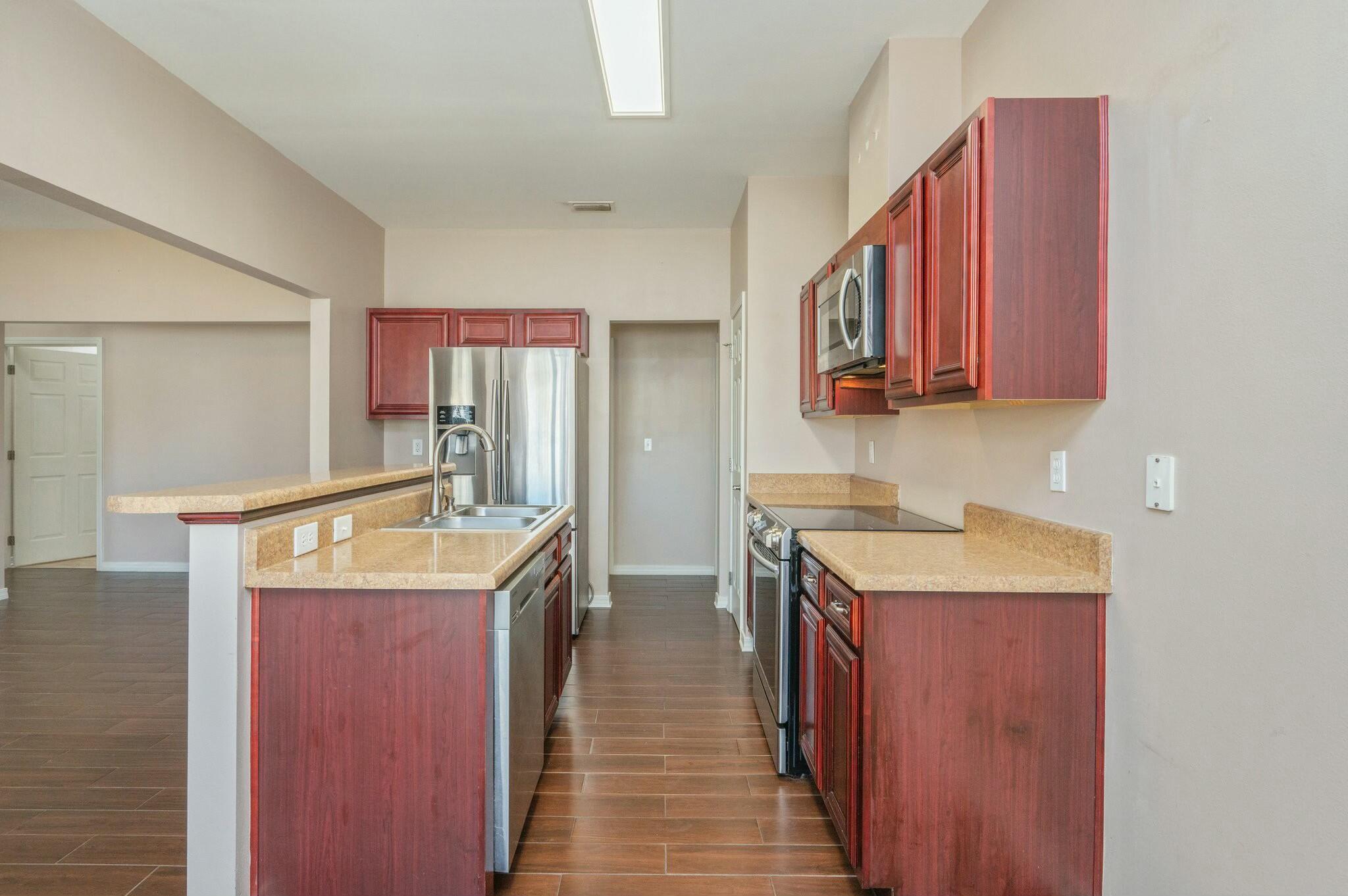 202 Ladue Avenue Crestview, FL 32539 - Photo 14 of 33 a kitchen with a sink stove top oven and wooden floor