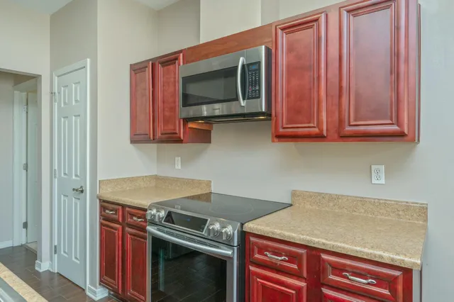 a kitchen with stainless steel appliances granite countertop a stove microwave and cabinets