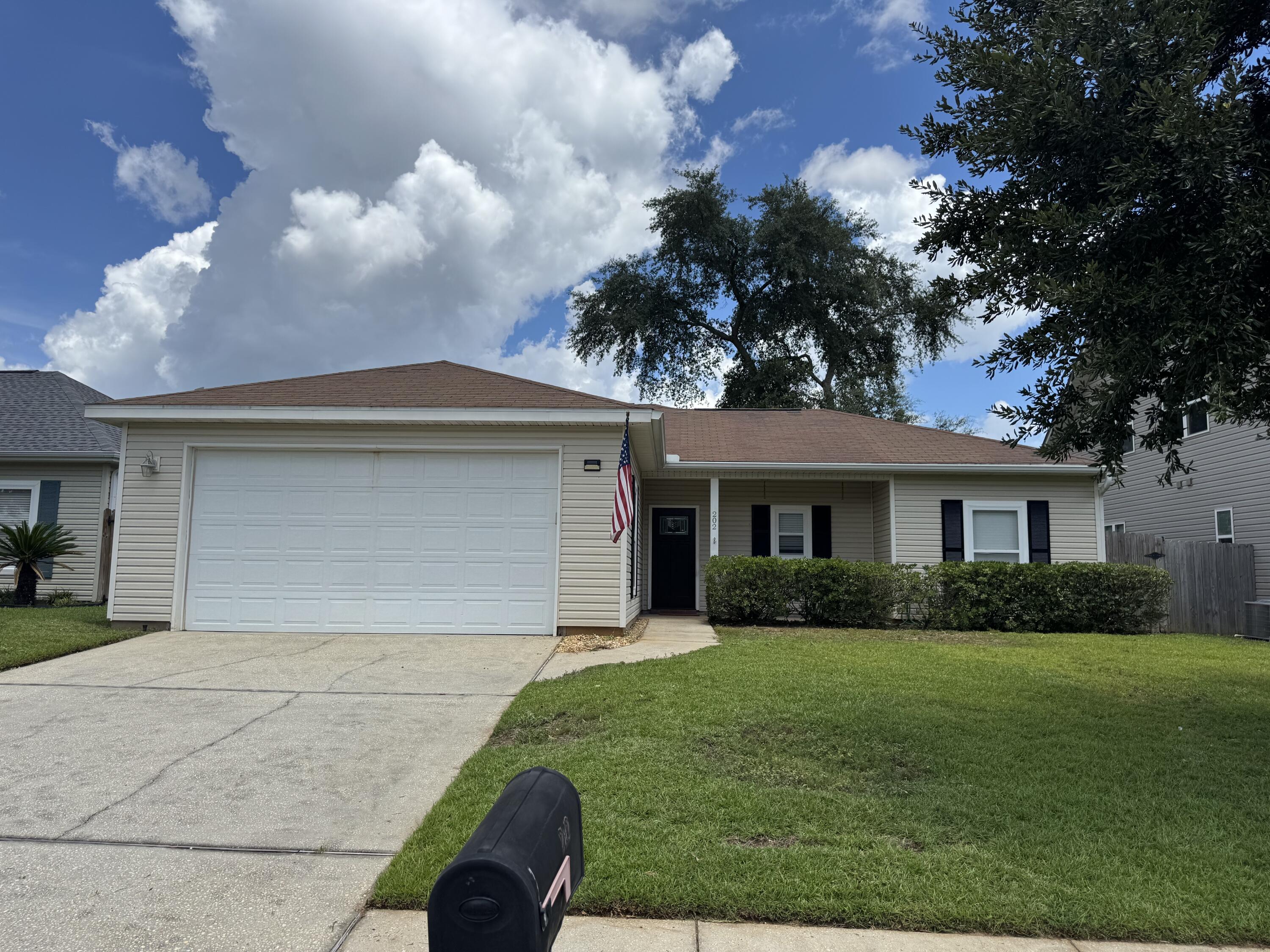 202 Ladue Avenue Crestview, FL 32539 - Photo 2 of 33 a front view of a house with a yard and garage