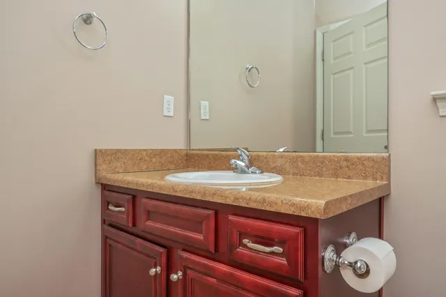 a bathroom with a granite countertop sink and a mirror