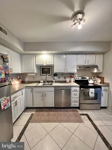 a kitchen with a sink cabinets and stainless steel appliances