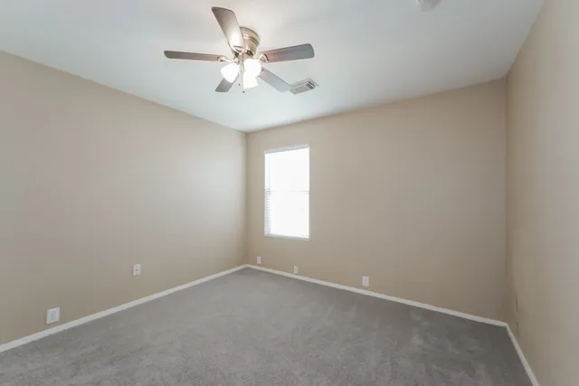 an empty room with a window and a fan