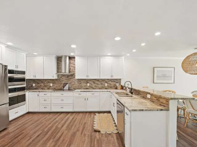 a kitchen with stainless steel appliances granite countertop a sink and cabinets