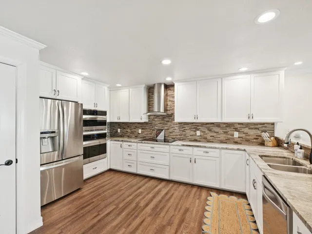 a kitchen with granite countertop a sink stove and refrigerator