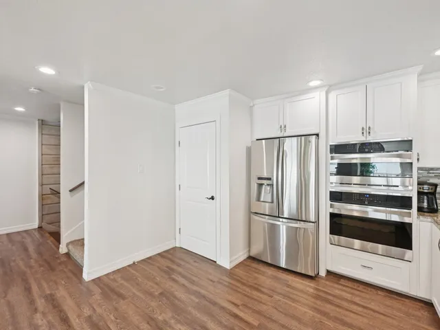 a kitchen with wooden floors and stainless steel appliances
