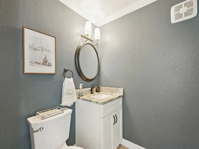 a bathroom with a granite countertop toilet sink and mirror