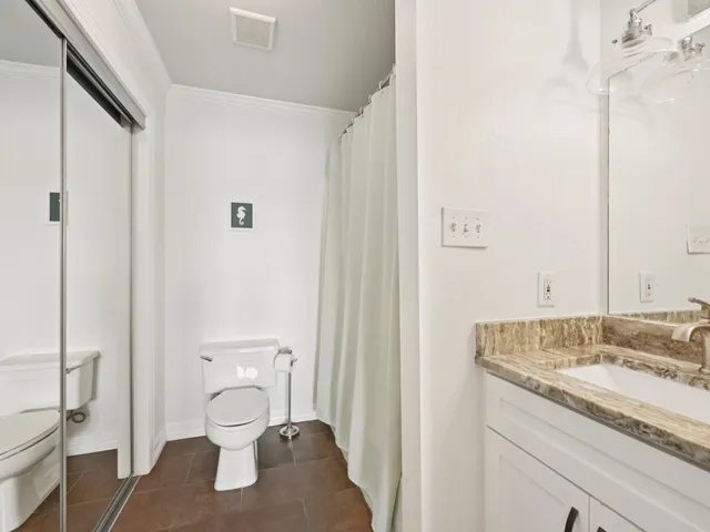 a bathroom with a granite countertop sink toilet and shower