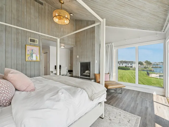 a bed sitting in a spacious bedroom next to a window