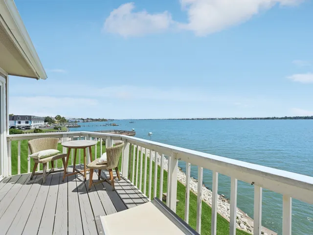 a view of a balcony with wooden floor and fence