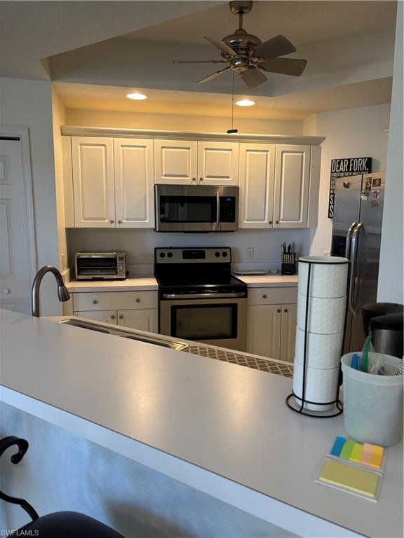 1270 Shady Rest Lane, Unit 403 Naples, FL 34103 - Photo 19 of 24 a kitchen with stainless steel appliances granite countertop a refrigerator a stove a sink dishwasher and a microwave with wooden floor