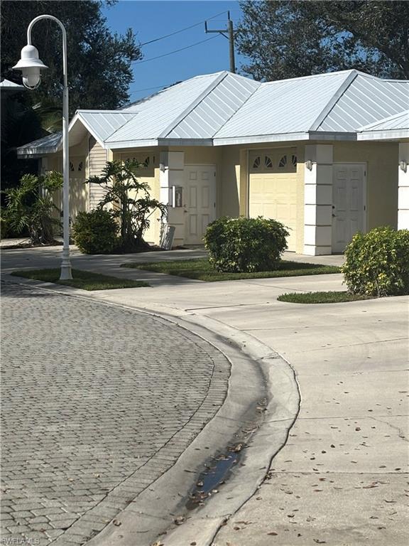 1270 Shady Rest Lane, Unit 403 Naples, FL 34103 - Photo 2 of 24 a front view of a house with garden
