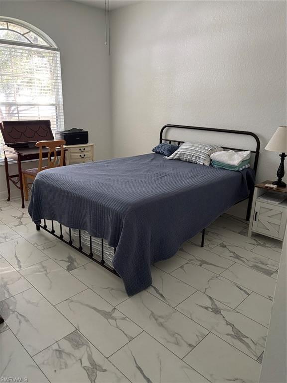 1270 Shady Rest Lane, Unit 403 Naples, FL 34103 - Photo 23 of 24 a bedroom with a bed and window