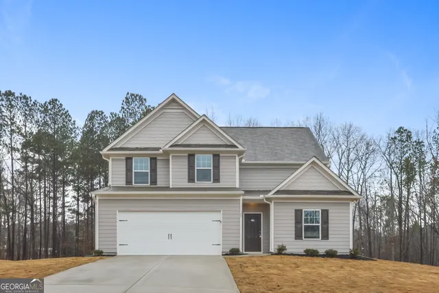 a view of a house with a yard and large tree
