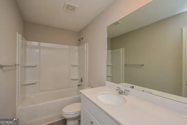 a bathroom with a bathtub shower sink vanity and toilet