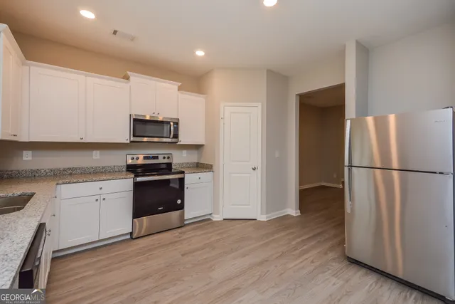 a kitchen with a refrigerator and a stove top oven
