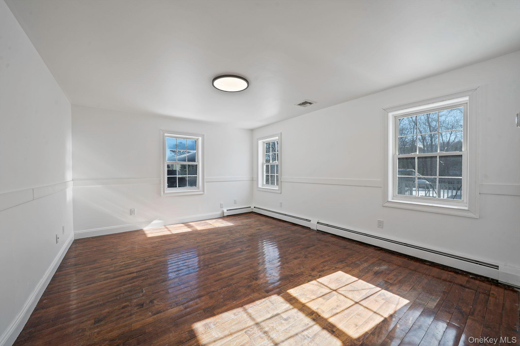 128 Bethune Boulevard Spring Valley, NY 10977 - Photo 15 of 34 an empty room with wooden floor and windows