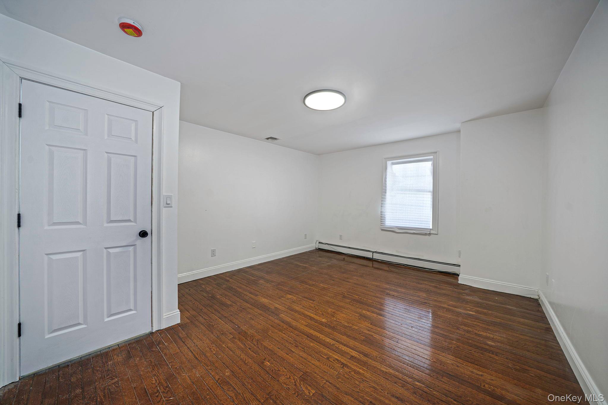 128 Bethune Boulevard Spring Valley, NY 10977 - Photo 26 of 34 a view of an empty room with wooden floor and a window