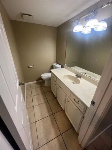 a spacious bathroom with a sink a toilet and a mirror